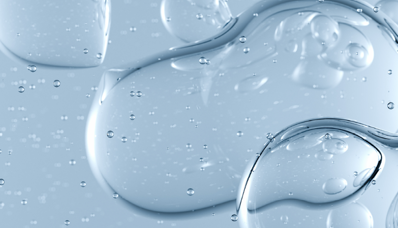 Große, transparente Blasen mit weichen Konturen schweben vor einem hellblauen Hintergrund. Kleine Luftbläschen verteilen sich gleichmäßig im gesamten Bild. Die Darstellung wirkt abstrakt und erinnert an Flüssigkeit oder Gas in Bewegung.